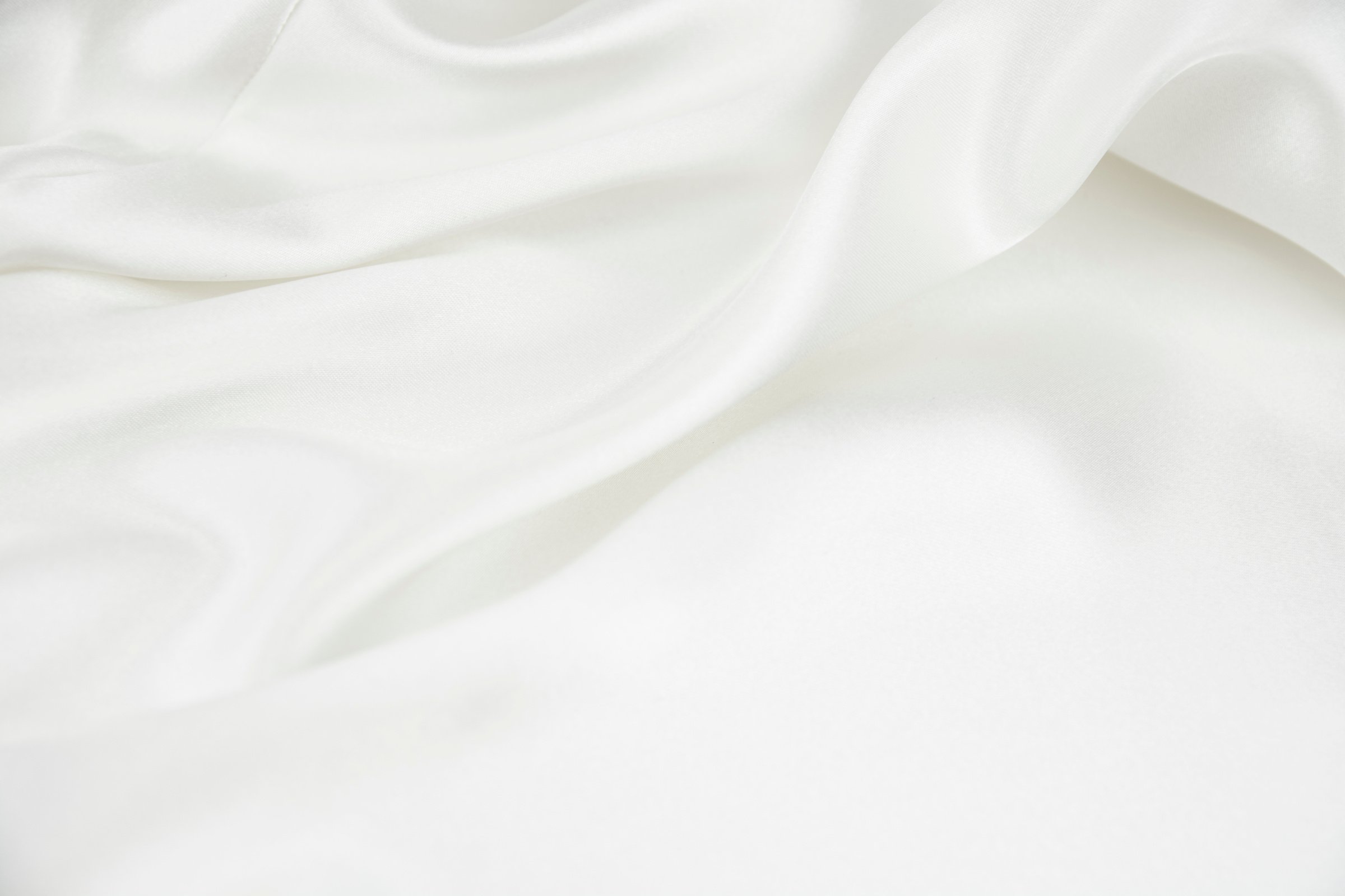 The texture of the satin fabric of white color for the background